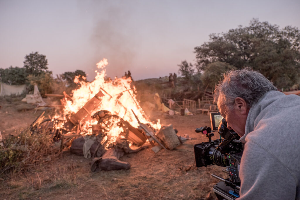 Behind-the-scenes still from production of "The Promise" - a cameraman captures a bonfire of Armenian's possessions as they were forced to flee because of the impending genocide